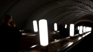 Metrodaki insanlar yürüyen merdivene biniyor. Kalabalık yaşam tarzı videosunu bulanıklaştırdı