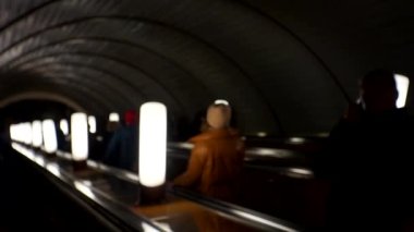 Metrodaki insanlar yürüyen merdivene biniyor. Kalabalık yaşam tarzı videosunu bulanıklaştırdı