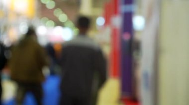 Modern bir iş merkezinin içindeki büyük bir salonda bir sürü insan var..