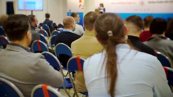 Mucha gente irreconocible está sentada en el auditorio — Vídeos de Stock