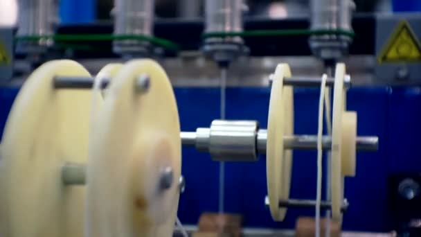 Several threads are pulled through the rotating parts of the textile machine. — Stock Video