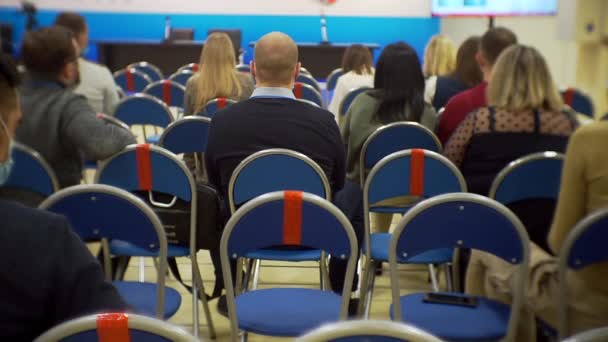 Mucha gente irreconocible sentada en el gran salón de la conferencia de negocios — Vídeos de Stock