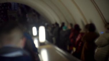 .Yürüyen merdivenlerde ilerleyen bulanık insan kalabalığı. Yeraltı metro kavramı..