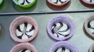 Üretim hattında parlak waffle bardaklarında çikolatalı kremalı dondurma..