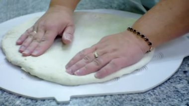 Yemek pişirmek. Aşçı mutfakta çiğ hamur ile çalışır. Yakın plan.