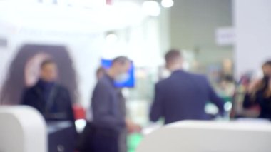 Büyük, parlak bir salondaki bir iş toplantısında tanınmayan insanlar.