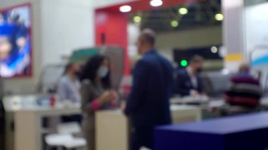 Büyük, parlak bir salondaki bir iş toplantısında tanınmayan insanlar.