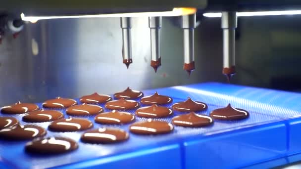 Vloeibare chocolademassa wordt uit de machine gegoten. close-up — Stockvideo
