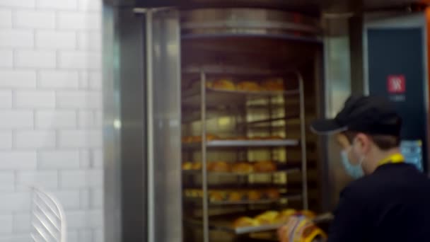 Неузнаваемый человек вытаскивает лист булочек из духовки — стоковое видео