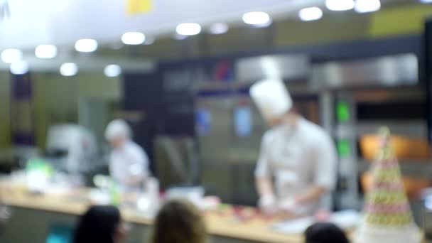 Präsentation von Geschäftsprodukten. Köche führen einen Meisterkurs vor Publikum durch. Unscharfer Hintergrund für ein kulinarisches oder geschäftliches Thema — Stockvideo