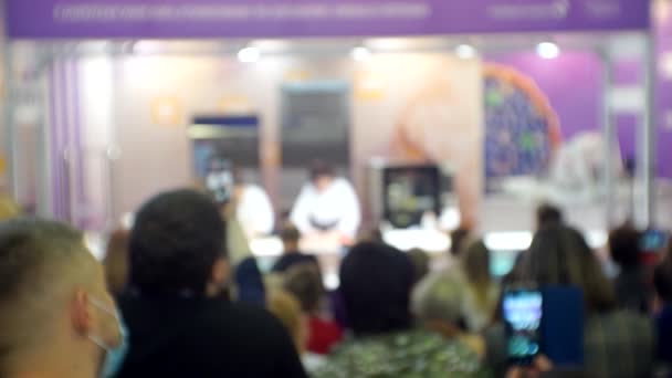 Chefs perform in front of the public giving a business presentation of a product. Blurred background for a culinary or business theme — Stock Video