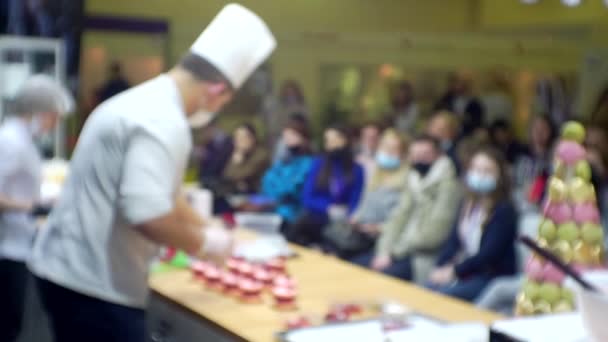 Chefs treden op voor het publiek en geven een zakelijke presentatie van een product. Wazige achtergrond voor een culinair of zakelijk thema — Stockvideo