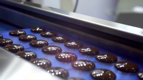 Moderno equipo de trabajo de alimentos. producción de chocolates.proceso tecnológico. masa de chocolate líquido se vierte desde la máquina. primer plano — Vídeos de Stock