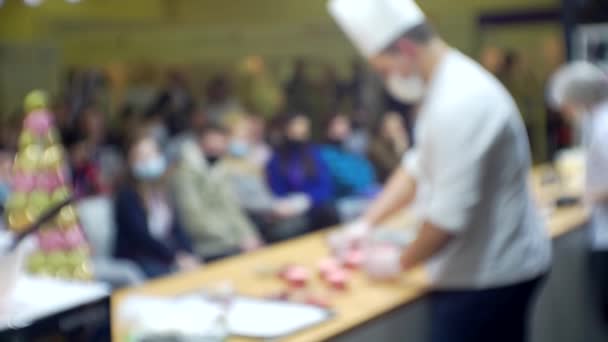 Kucharze wykonują przed publicznością prezentację biznesową produktu. Zamazane tło dla tematu kulinarnego lub biznesowego — Wideo stockowe