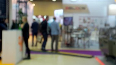 İş temasının arka planı bulanık. Büyük, parlak bir iş merkezinde tanınmayan insanlar.