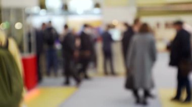 İş merkezinin içindeki büyük, parlak bir salonda birçok insan var. Bir iş temasının bulanık arkaplanı.