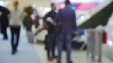 İş merkezinin içindeki büyük, parlak bir salonda birçok insan var. Bir iş temasının bulanık arkaplanı.