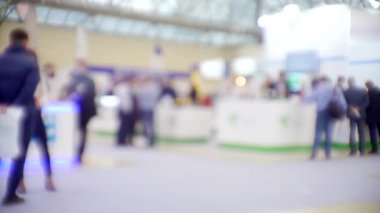 İş merkezinin içindeki büyük, parlak bir salonda birçok insan var. Bir iş temasının bulanık arkaplanı.