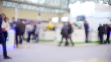 İş merkezinin içindeki büyük, parlak bir salonda birçok insan var. Bir iş temasının bulanık arkaplanı.