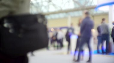İş temasının arka planı bulanık. Bir alışveriş merkezinde tanınmayan modern insanların siluetleri.
