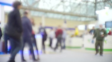 İş temasının arka planı bulanık. Bir alışveriş merkezinde tanınmayan modern insanların siluetleri.