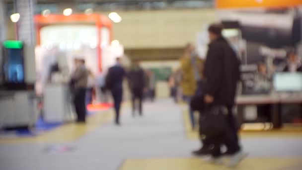 Sfondo sfumato su un tema aziendale. Silhouette di persone moderne irriconoscibili all'interno di un centro commerciale leggero — Video Stock