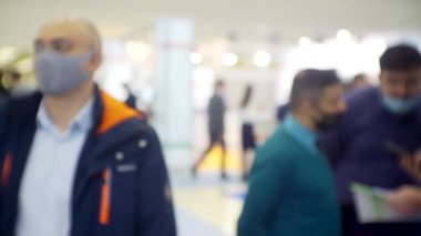 İş teması geçmişi. Büyük ve parlak bir iş merkezinde tanınmayan insanlar. Bulanık odaklı görüntü