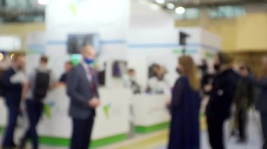 Film ekibi, büyük, parlak bir salonda bir işadamıyla röportaj yapıyor. Eğitim ve iş ile ilgili bulanık bir görüntü.