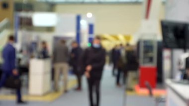 İş temasının arka planı bulanık. Bir alışveriş merkezinde tanınmayan modern insanların siluetleri.