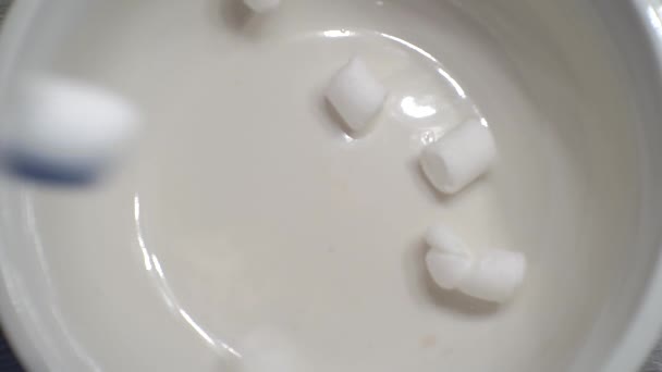 Aliments sucrés.une petite guimauve tombe dans une tasse. — Video