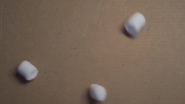 Söt mat. små marshmallows hälls i en pappkartong. närbild — Stockvideo