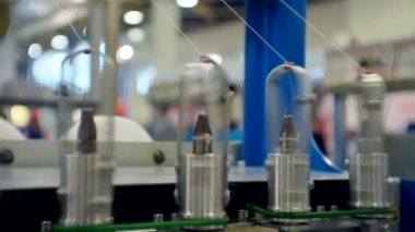 Teknolojik süreç. Teçhizatın bir parçası. Tekstil makinesinin dönen kısımlarından çeşitli iplikler çekiliyor. İş geçmişi.