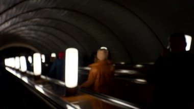 Yeraltı metrosu. Metrodaki tanınmayan insanlar yürüyen merdivene biniyor. Kalabalık yaşam tarzı videosunu bulanıklaştırdı