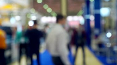 Büyük, parlak bir salonda tanınmayan insanlar. Bulanık arka plan.