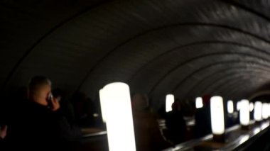 Yeraltı metro konsepti. Metrodaki tanınmayan insanlar yürüyen merdivene biniyor. Bir sürü insan yaşam tarzı videosunu bulanıklaştırdı. İnsanlar aşağı inip metro asansörüne çıkıyorlar.