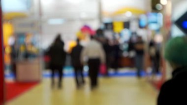 İş merkezinin içindeki büyük, parlak bir salonda birçok insan var. Bir iş temasının bulanık arkaplanı.