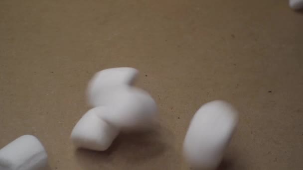 Comida doce. pequenos marshmallows são vertidos em uma caixa de papelão. vista superior. close-up — Vídeo de Stock