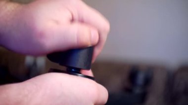 Mobilyaların montajı ve onarımı. Erkek eller ofis sandalyesinin direksiyonunu değiştiriyor. Yakın plan.