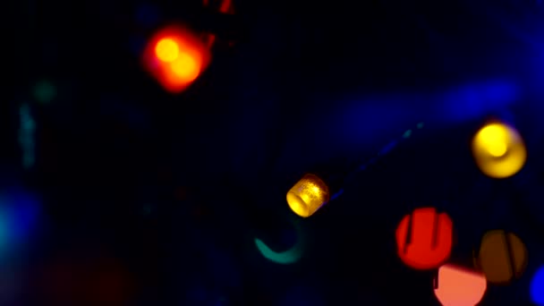 Nowy Rok i Boże Narodzenie. Małe światła elektryczne girlandy zapalają się i gasną w ciemności.Streszczenie świątecznego tła.Close-up — Wideo stockowe