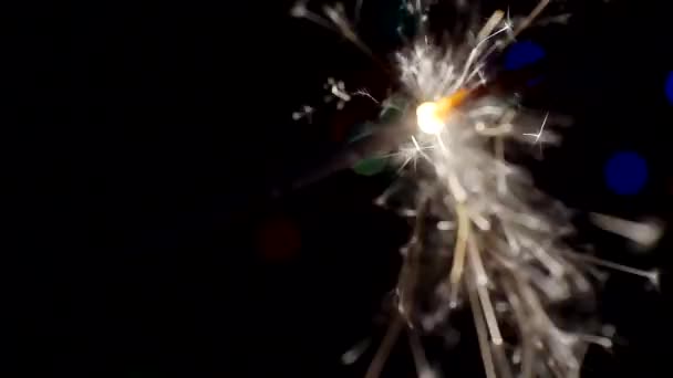 Neujahr und Weihnachten festlichen Hintergrund. Wunderkerzen brennen hell vor dem Hintergrund heller Bokeh-Kreise. Nahaufnahme. Geringe Tiefenschärfe — Stockvideo