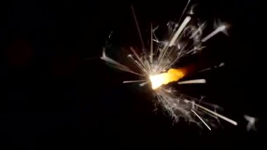 Yılbaşı ve Noel festivali geçmişi. Sparkler parlak bokeh çemberlerinin arka planında parlak bir şekilde yanar. Yakın plan. Sığ alan derinliği