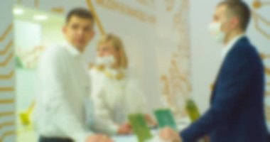 Bir iş temasının arka planı. Büyük, parlak bir salondaki bir iş toplantısında tezgahta iletişim kuran iş adamlarının siluetleri bulanıklaştı.