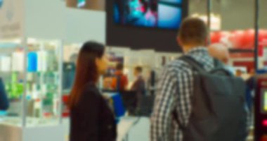 Bir iş temasının arka planı. Büyük, parlak bir salondaki bir iş toplantısında tezgahta iletişim kuran işadamlarının ve kadınların siluetleri bulanıklaştı.