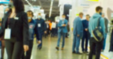 İş teması geçmişi. Büyük ve parlak bir iş merkezinde tanınmayan insanlar. Bulanık odaklı görüntü