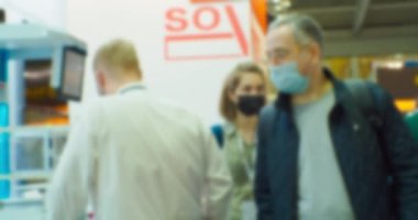 İş merkezinin içindeki büyük, parlak bir salonda birçok insan var. Bir iş temasının bulanık arkaplanı.