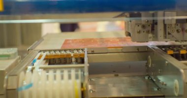 Yüksek teknoloji ürünü. Elektronik üretimi için modern bir endüstriyel robot kompleks baskılı devre tahtası yapıyor. Yakın plan.