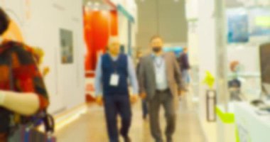 İş temasının arka planı bulanık. Büyük, parlak bir iş merkezinde tanınmayan insanlar.