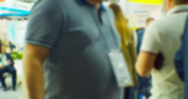 İş merkezinin içindeki büyük, parlak bir salonda birçok insan var. Bir iş temasının bulanık arkaplanı.