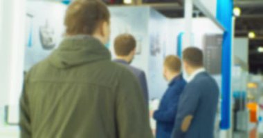 İş merkezinin içindeki büyük, parlak bir salonda birçok insan var. Bir iş temasının bulanık arkaplanı.