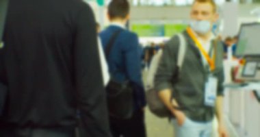 İş merkezinin içindeki büyük, parlak bir salonda birçok insan var. Bir iş temasının bulanık arkaplanı.